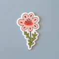 Floral patch with pink flower and green leaves on a gray background