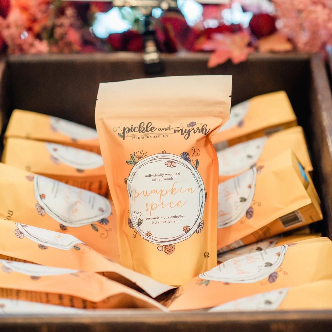 A plastic bag filled with caramel candies. The bag has a label that says "Pickle & Myrrh" and "Pumpkin Spice."