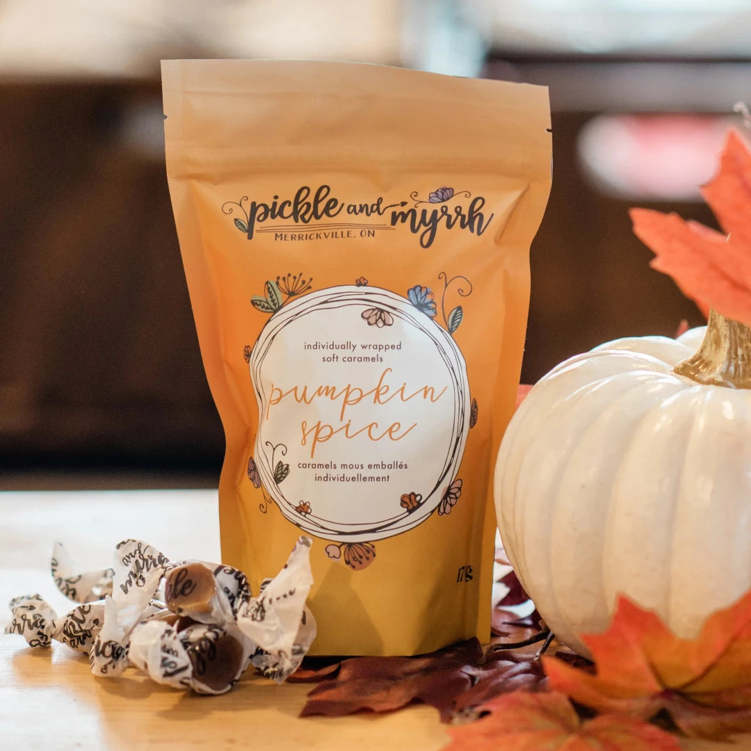A plastic bag filled with caramel candies. The bag has a label that says "Pickle & Myrrh" and "Pumpkin Spice."