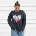 a grey sweatshirt with a large, heart-shaped patch. The patch is made from various fabrics with various patterns, sewn together in a patchwork style.