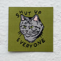 Embroidered patch with a cat illustration and text 'SHUT UP EVERYONE' on a green background.