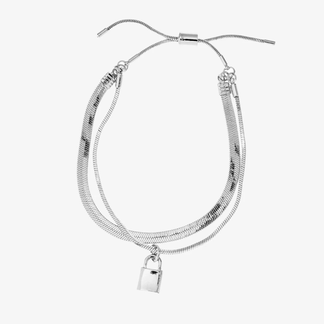 A silver layered bracelet with a small padlock charm. The bracelet has two chains of different widths, and the padlock charm hangs from the thinner chain.