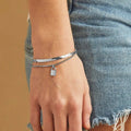 A silver layered bracelet with a small padlock charm. The bracelet has two chains of different widths, and the padlock charm hangs from the thinner chain.