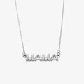 A silver necklace on a pink background. The necklace features a silver pendant with the word "MAMA" in bold letters. The text "COOL MAMA FOREVER" is printed on the background card, along with the brand name "Foxy Originals."