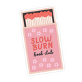 Matches in a pink matchbox with 'Slow Burn Book Club' text and flower designs on a white background