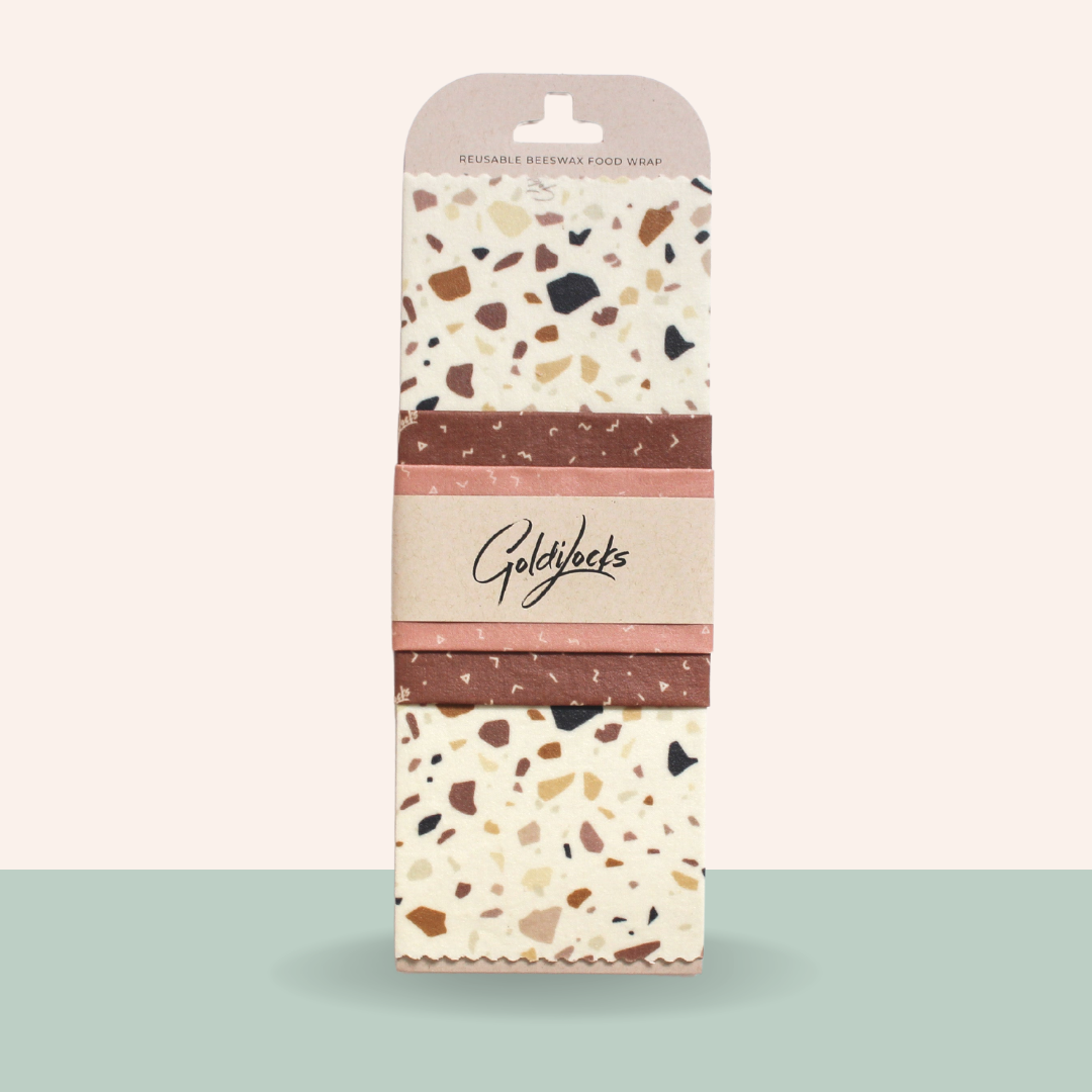 Pack of Goldylocks beeswax food wraps with terrazzo pattern on a light green background