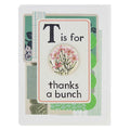 A thank you card designed like a vintage flashcard. The card has a white background with green patterned borders and layered paper effects. The main flashcard design is white with a red border, and it reads "T is for" at the top. Below this is a round button with an image of pink flowers. The bottom of the flashcard reads "thanks a bunch".