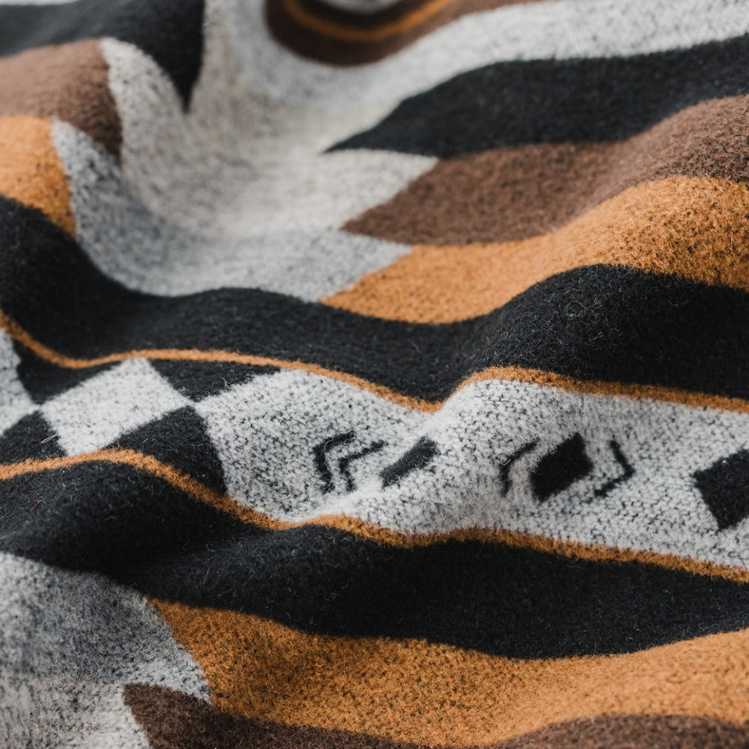 The Thunderbird Reversible Eco-Friendly Blanket by Mini Tipi, featuring bold Indigenous-inspired Thunderbird and geometric patterns in black, grey, and brown. This sustainable and culturally significant blanket is available in Ottawa, Ontario, Canada.
