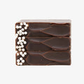 Three stacked chocolate bars with white specks on a white background