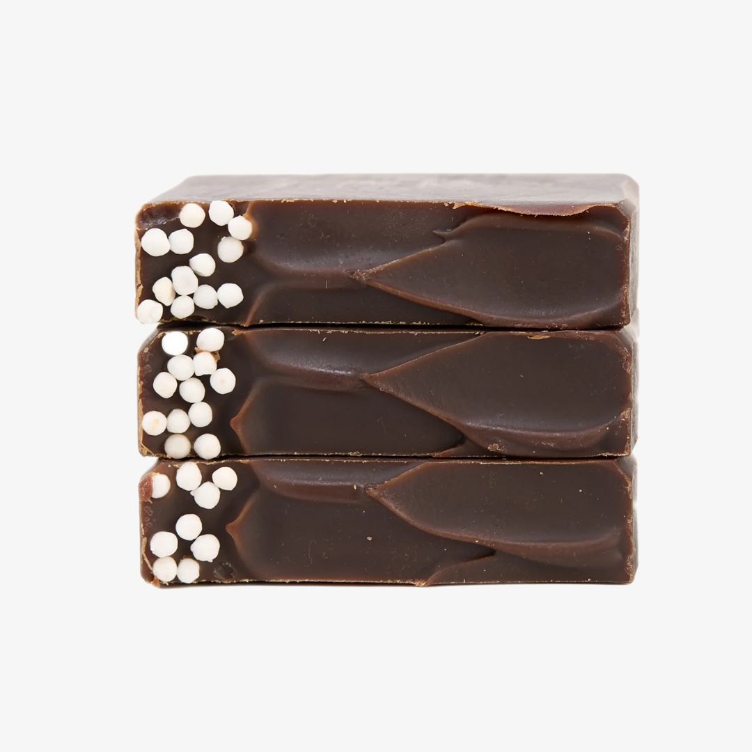 Three stacked chocolate bars with white specks on a white background