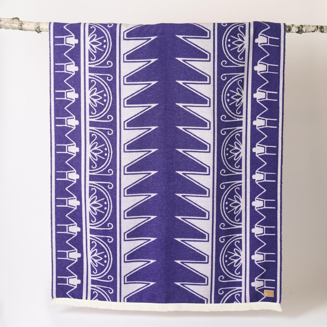 Purple and white patterned towel hanging on a rack against a white background