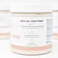 Jar of coconut bath salts with usage instructions on a white background