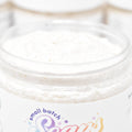 Jar of whipped cream with 'small batch' and 'Sara's' branding on a light wooden surface.