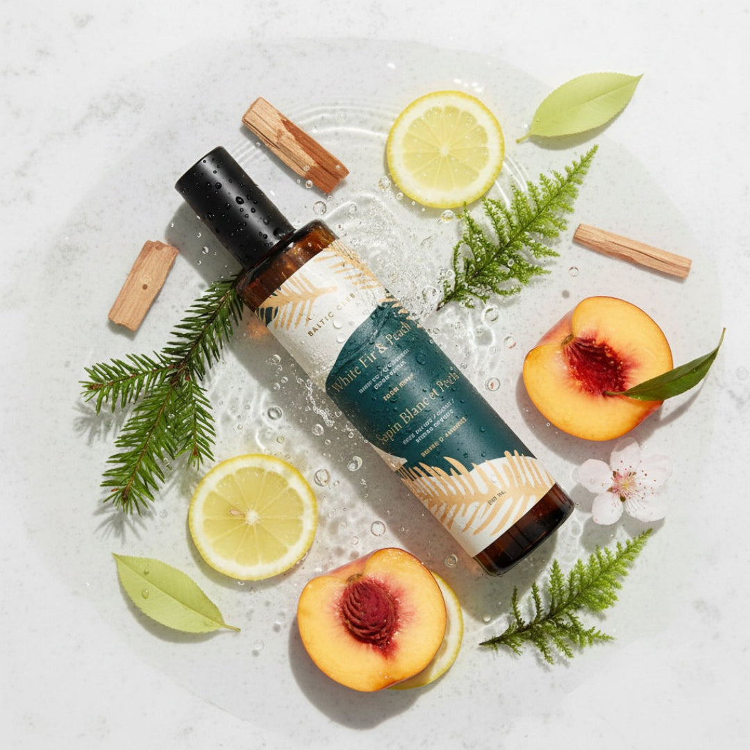 Skincare bottle with lemon slices, peach halves, and green leaves on a light background