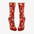 A pair of dark red women's crew socks with a winding vine pattern featuring yellow and pink tulip-shaped flowers. Text on one sock reads "I WORK MY ASS OFF".