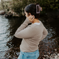 Woman adjusting her hair by a lakeside