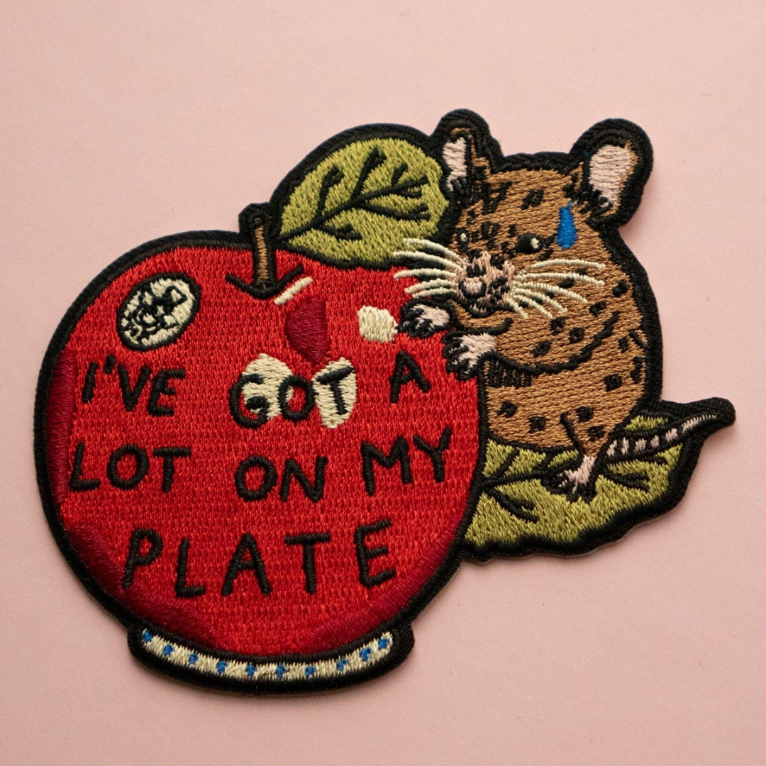 Patch with a mouse and apple design on a pink background