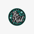 Circular sticker with 'Be Kind' text and decorative elements on a white background