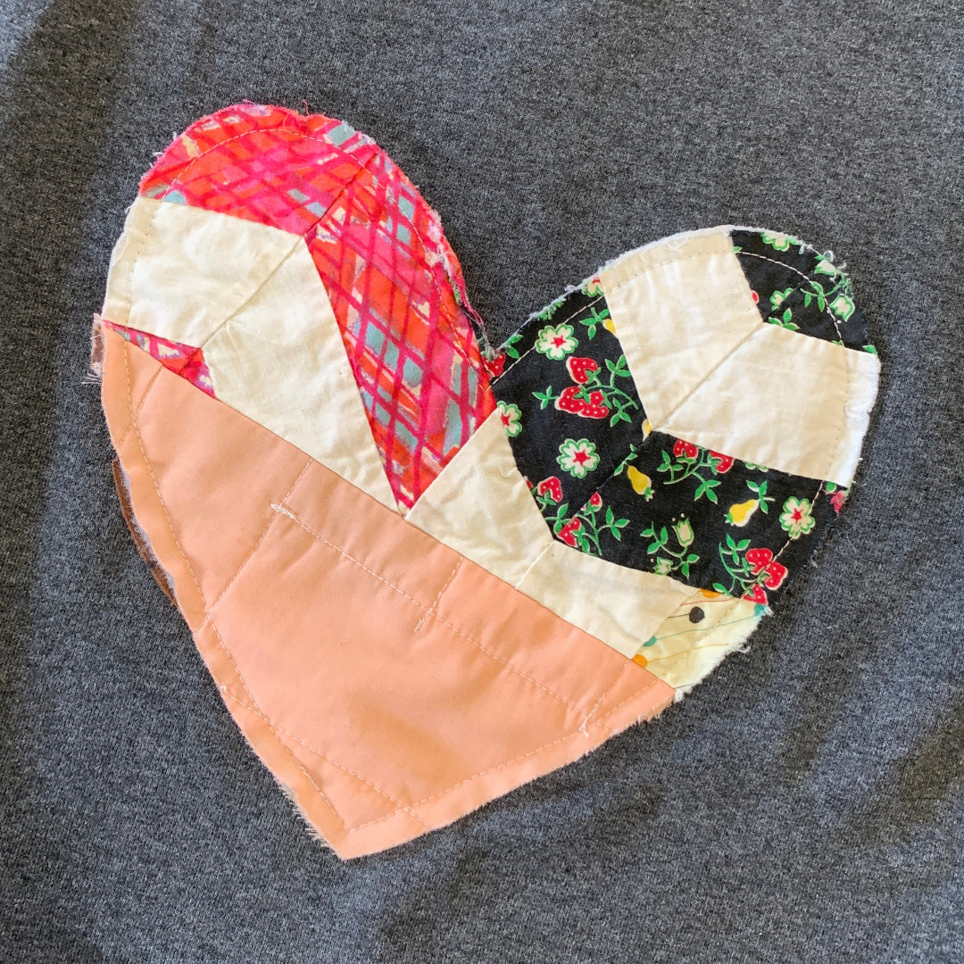 Gray sweatshirt with a colorful patch on a dark background