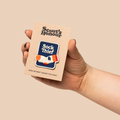 Hand holding a 'Scout's Honour' product against a beige background