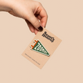 Hand holding a Scout's Honour Zoomies card against a beige background