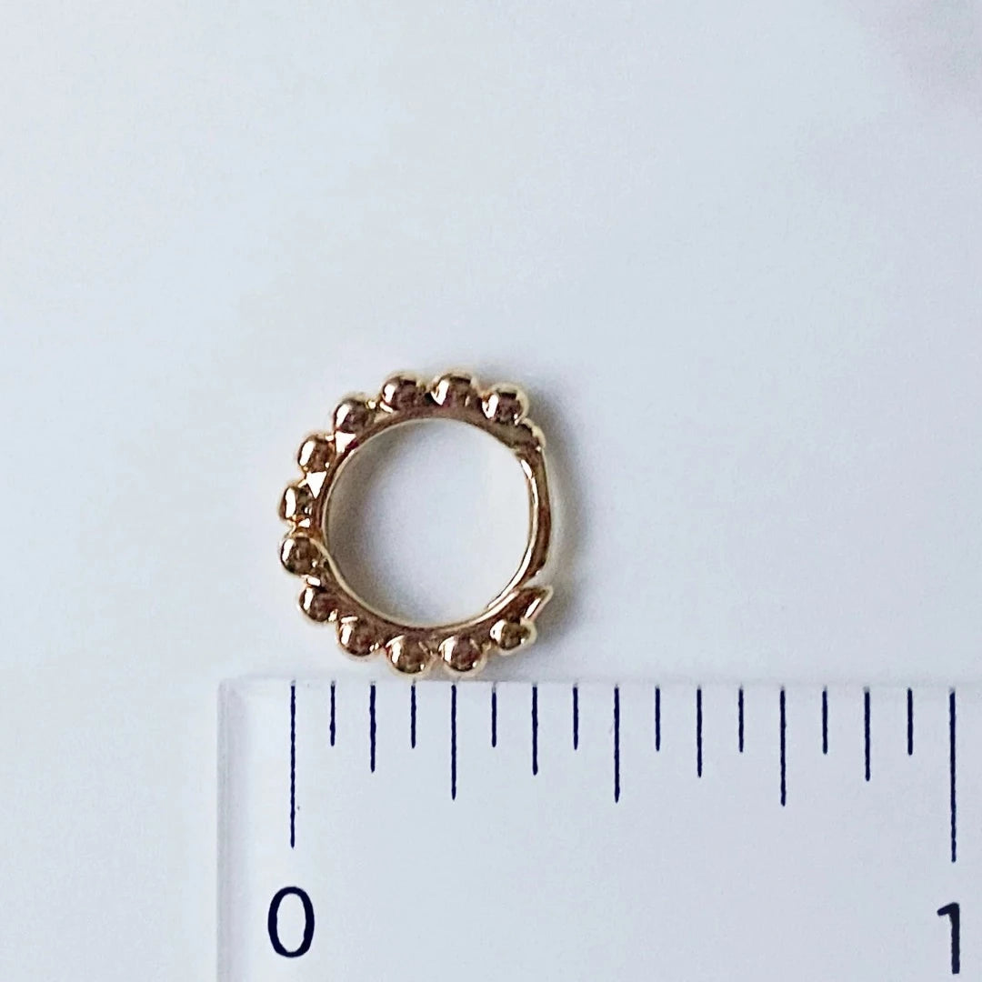 A pair of 14K Gold Ball Hoop Cuffs by agaveh girl, featuring a beaded design, displayed on a branded card with the text 'agaveh girl,' against a textured background. The earrings are dainty and high-quality, available in Ottawa, Ontario, Canada.