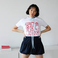 Person wearing a white t-shirt with red and blue graphics and black shorts against a plain background