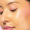 Red-dy or Not Lip & Cheek Tinted Balm, a liquid blush used on a medium skin toned woman's eyes, cheeks and lips.