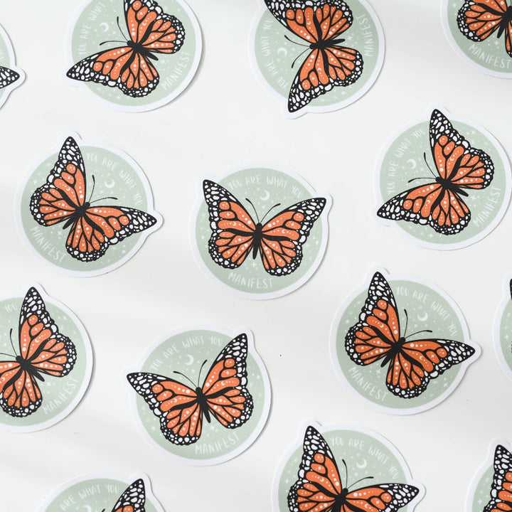 a bunch of You Are What You Manifest Sticker, a green sticker with a monarch butterfly in the middle with the words 
