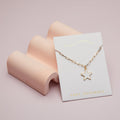 Gold star necklace on a 'Foxy Originals' card with a pink background