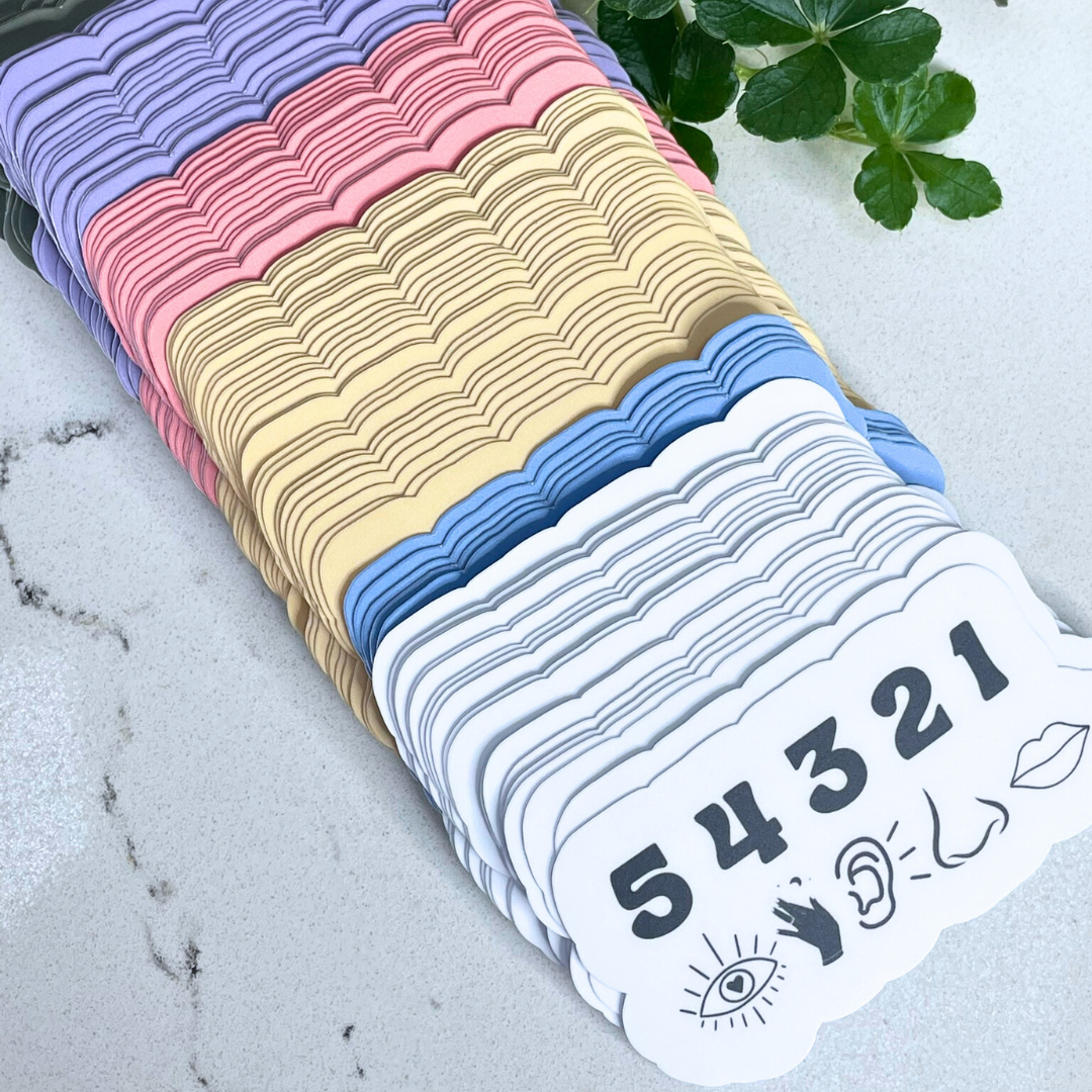 Stack of colorful cards with numbers and symbols on a marble surface