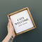 A white framed box sign with the text 