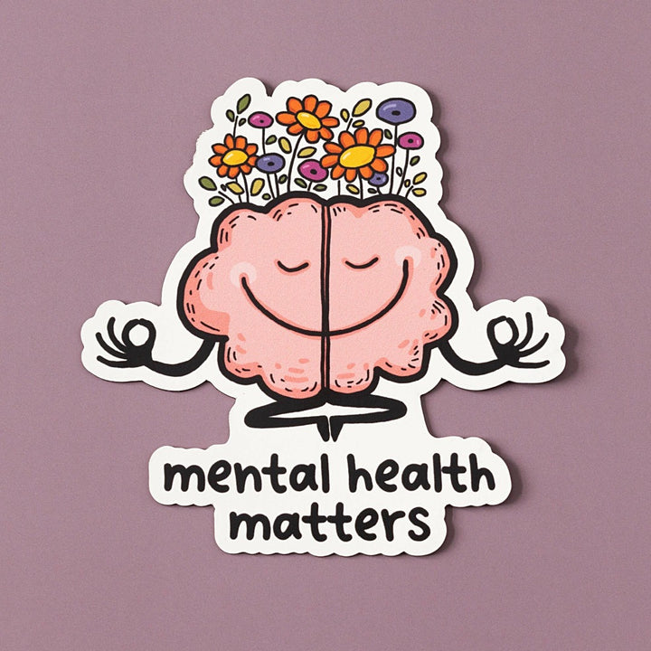A pink cartoon brain with a smiling face is meditating. The brain has flowers growing from the top and is surrounded by the text 