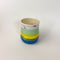 Peaceful Thumb Mug, a handless mug with a blue to green striped design and speckles finish.