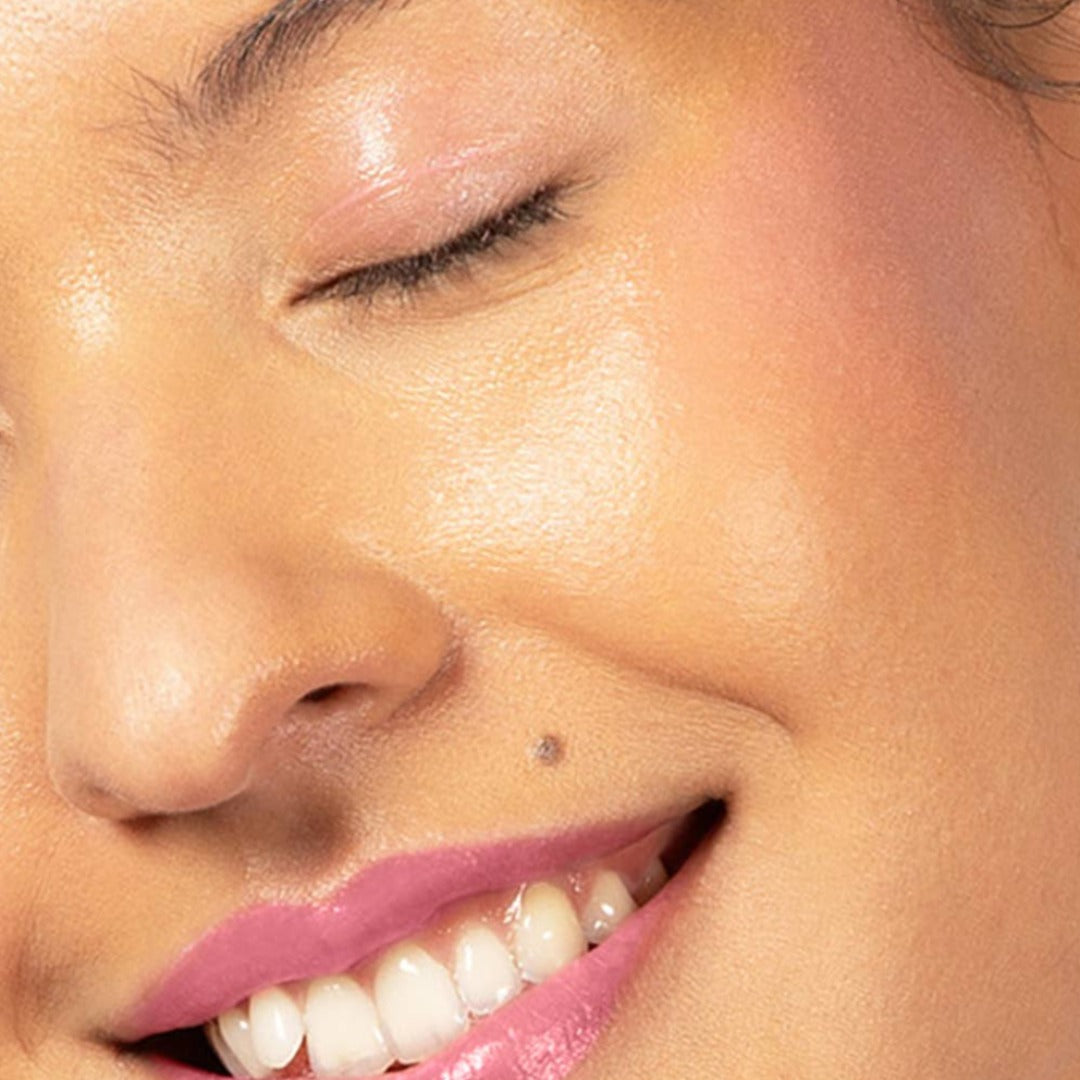 Red-dy or Not Lip & Cheek Tinted Balm, a liquid blush used on a medium skin toned woman's eyes, cheeks and lips.