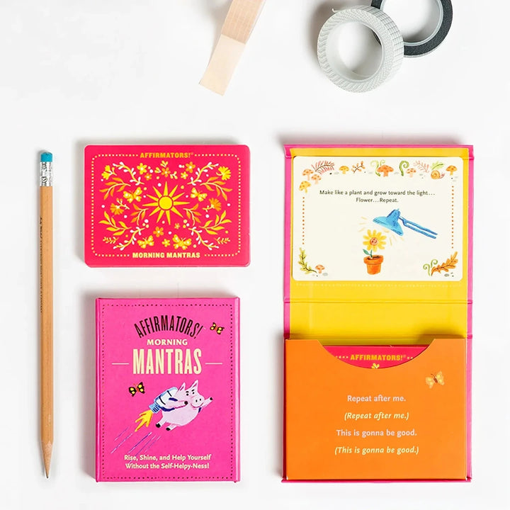 A pink box containing a deck of affirmation cards. The box has the text 