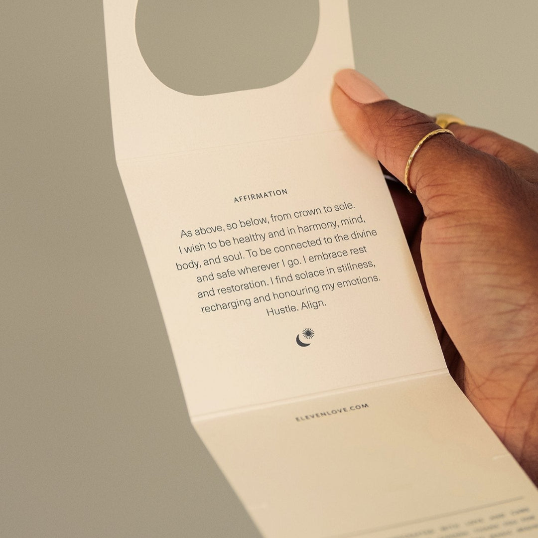 Hand holding a folded card with text and a circular cutout on a plain background
