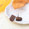 A pair of wooden earrings shaped like rainbows.