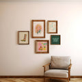 Framed artworks on a wall with a chair below