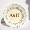 Decorative plate with 'As If' text on a white background
