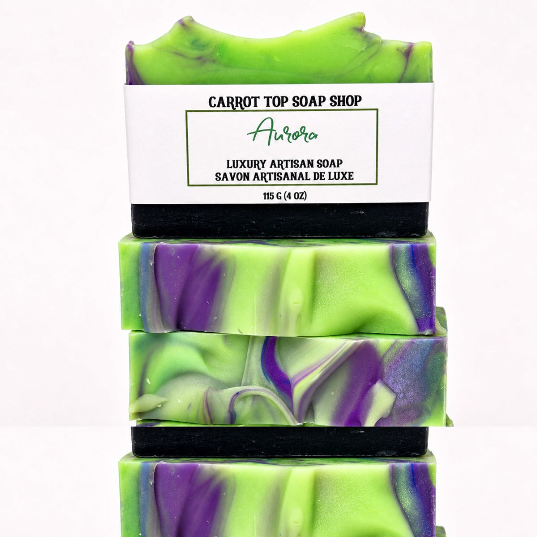 Four stacked bars of Carrot Top Soap Shop Aurora luxury artisan soap, featuring a vibrant lime green and purple marbled pattern with black soap bands and a white paper label.