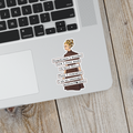 Laptop with a sticker of a woman and text on a wooden surface