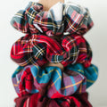 Plaid scrunchies on a wooden block with 'Barbays' branding