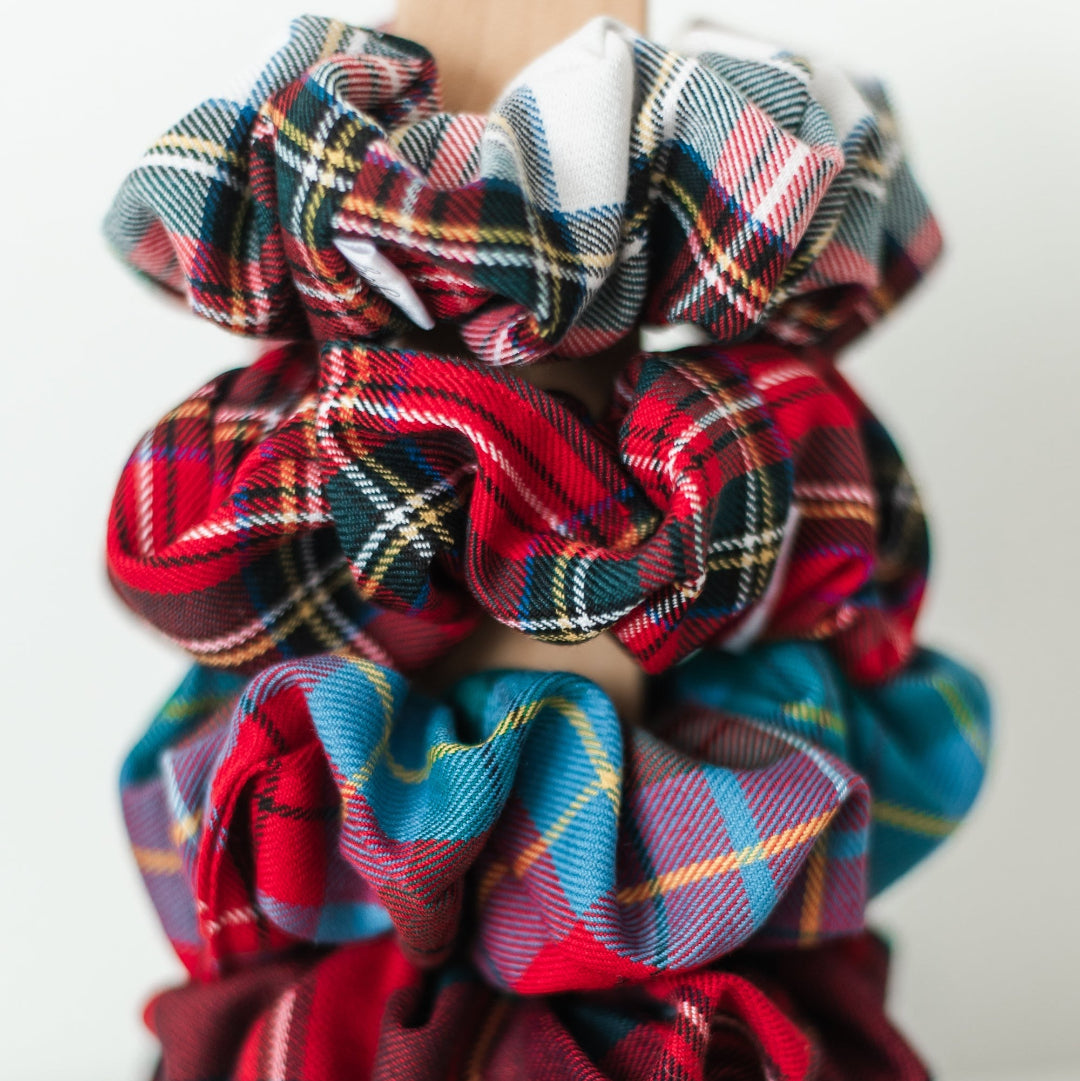 Plaid scrunchies on a wooden block with 'Barbays' branding