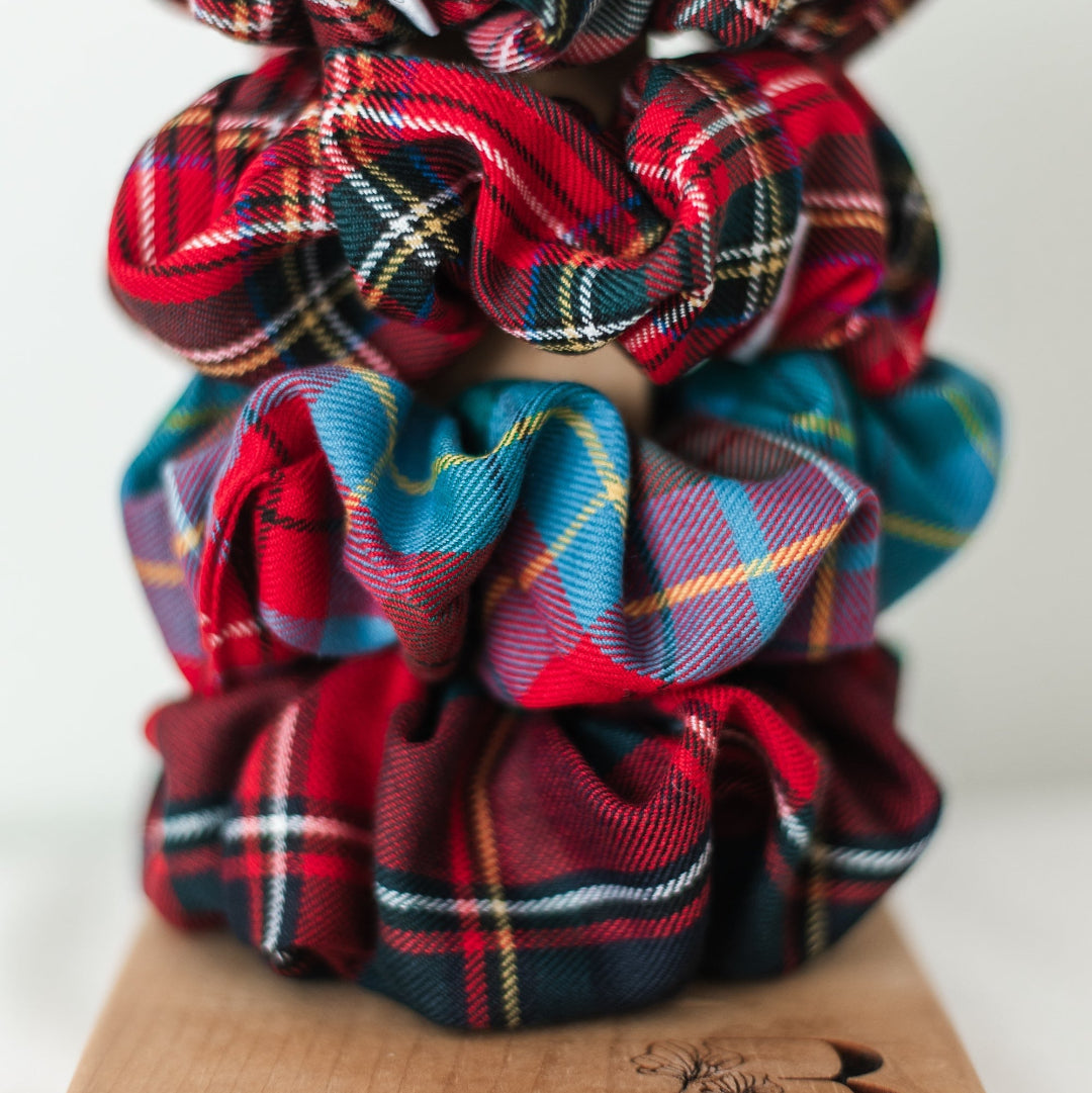 Plaid scrunchies on a wooden block with 'Barbays' branding