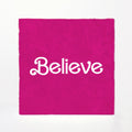 Pink fabric with 'Believe' printed in white on a white background