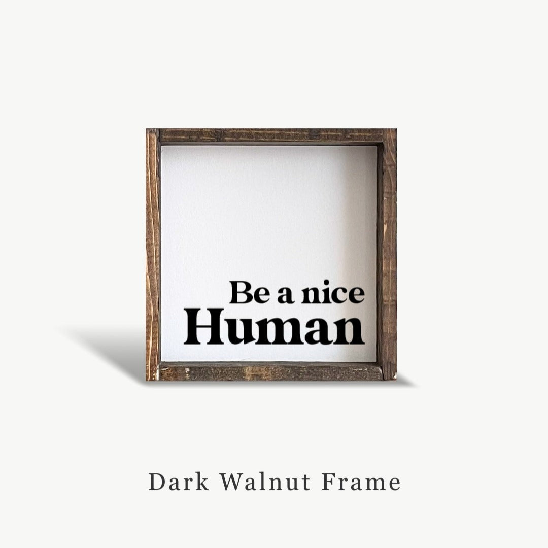 Wooden frame with 'Be a nice Human' text on a white background