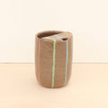 Ceramic vase with horizontal stripes on a beige background