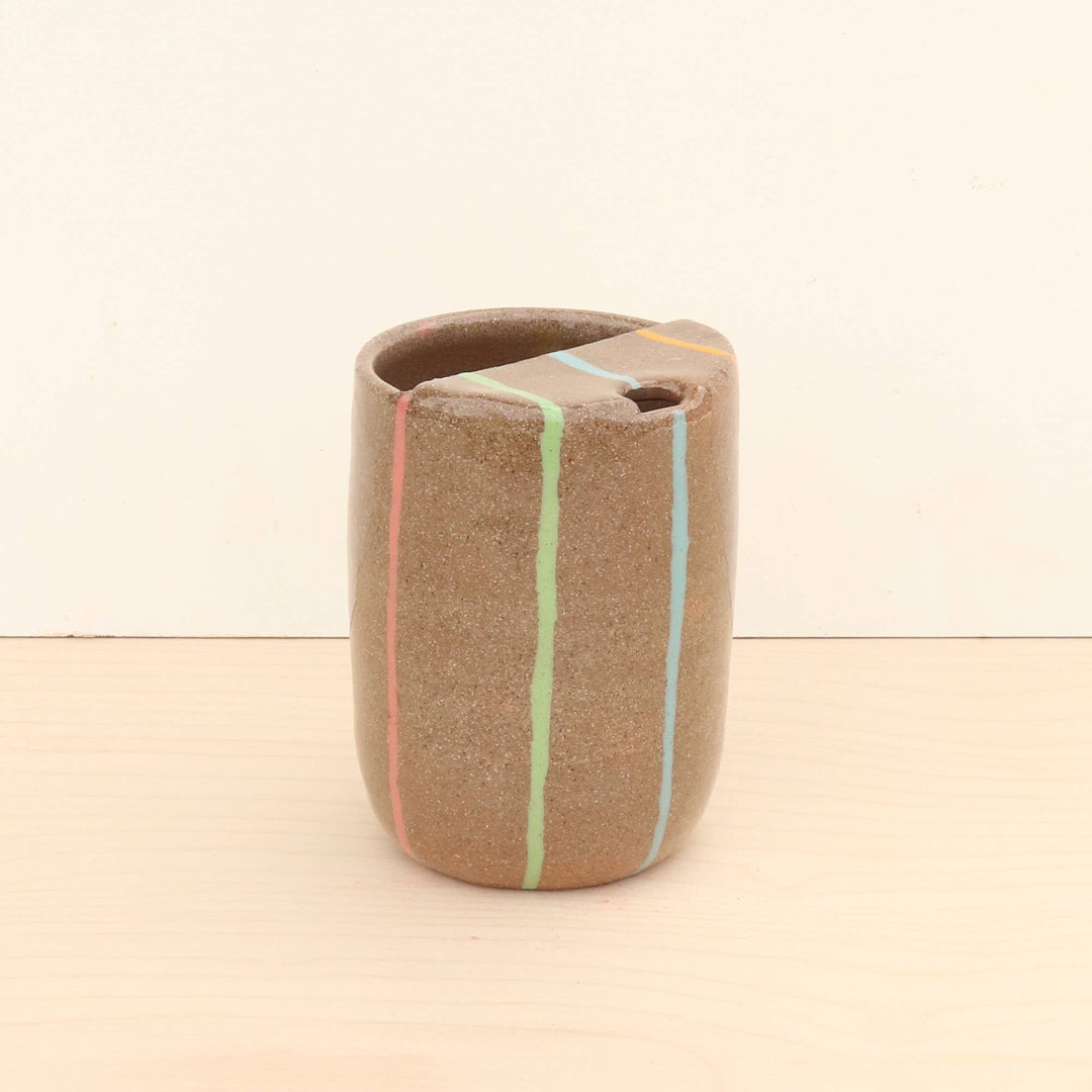 Ceramic vase with horizontal stripes on a beige background