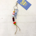 Colorful beaded keychain with a 'Cat Wand' branded tag on a textured white surface